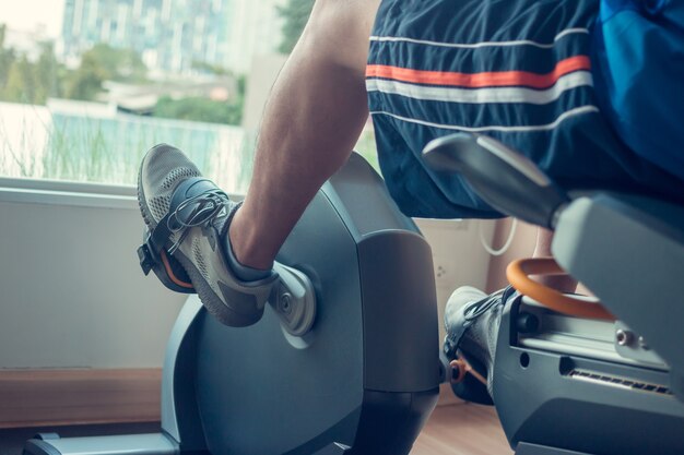 Young man using a spinning bike in an indoor fitness center