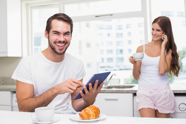 Young man using tablet pc at breakfast