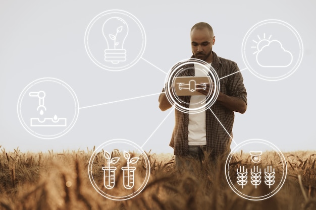 Young man using tablet in wheat field close up, agricultural concept