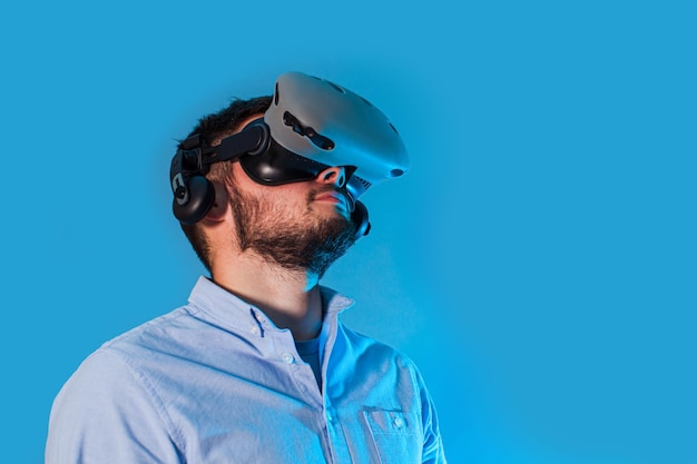 Young man using the virtual reality glasses two gamepad and playing video game