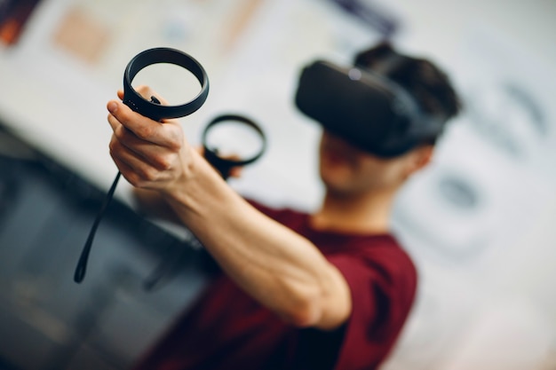 Photo young man in virtual reality goggles, vr glasses headset with joystick