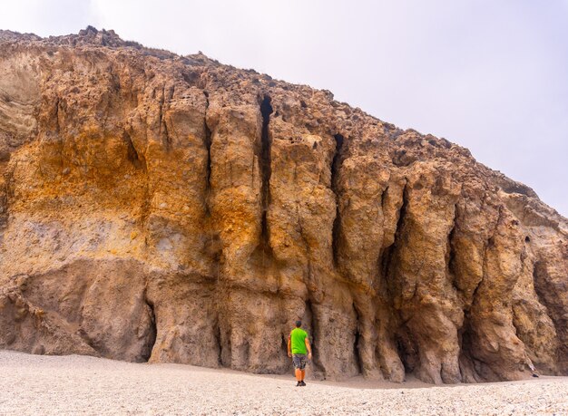 A young man visiting the beautiful natural walls of Playa de los Muertos in the natural park of Cabo de Gata, Nijar, Andalucia. Spain