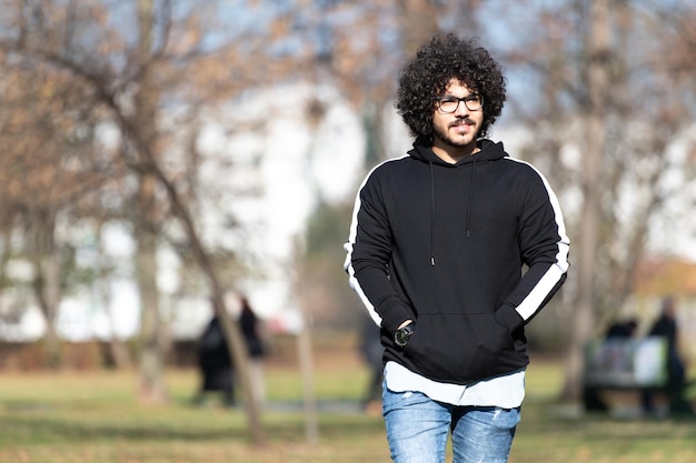 Young Man Walking in Autumn Forest