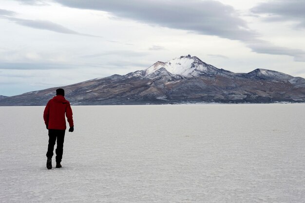 Photo young man walking in desert in bolivia