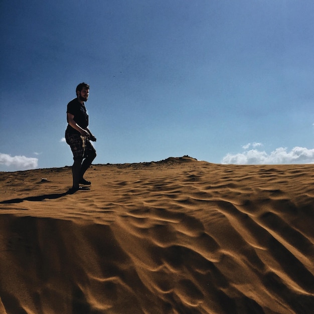 Photo young man walking at desert