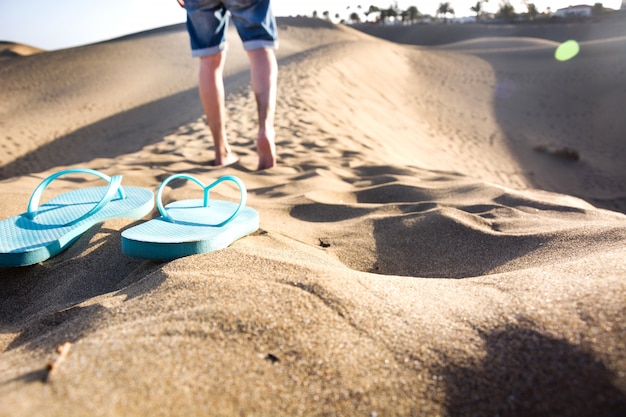 young man walking down a dune