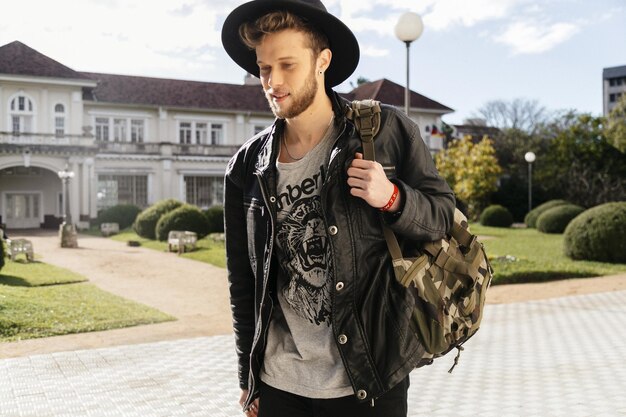 Photo young man walking on footpath at park