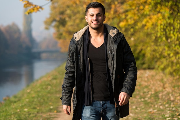 Young Man Walking In Forest Through The Woods Outside During Autumn