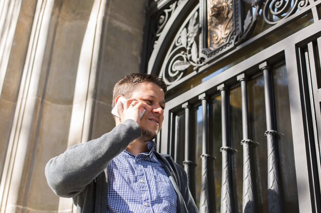 Young man walking on the street and talking by phone