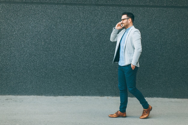 Young man walking and talking over the mobile phone  outdoor