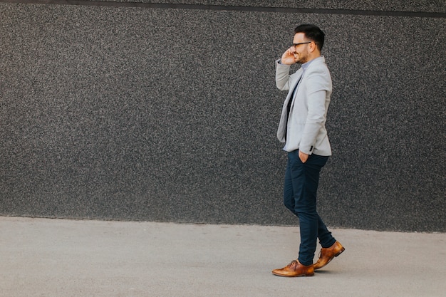 Young man walking and talking over the mobile phone  outdoor