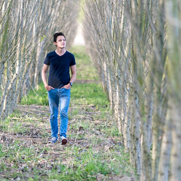 a young man walks through the woods