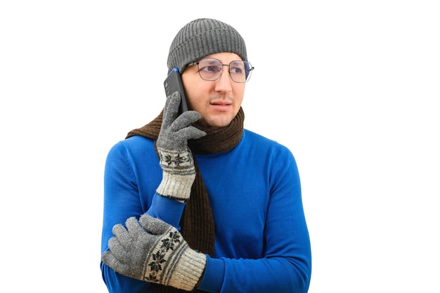 Young man in warm clothes talking on the phone on a white background cold winter season