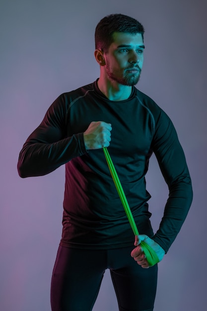 Young man warming up with resistance band before workout