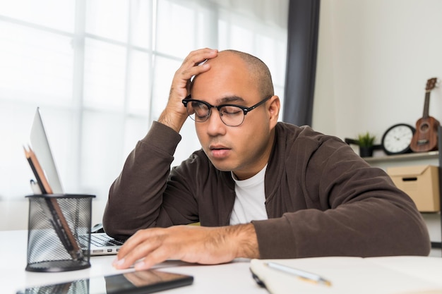 The young man was working in front of the laptop he was tired And fell asleep on the desk