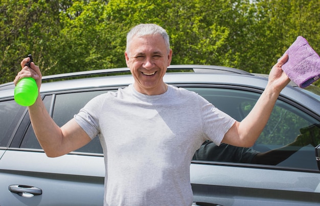 スポンジで車を洗う若い男