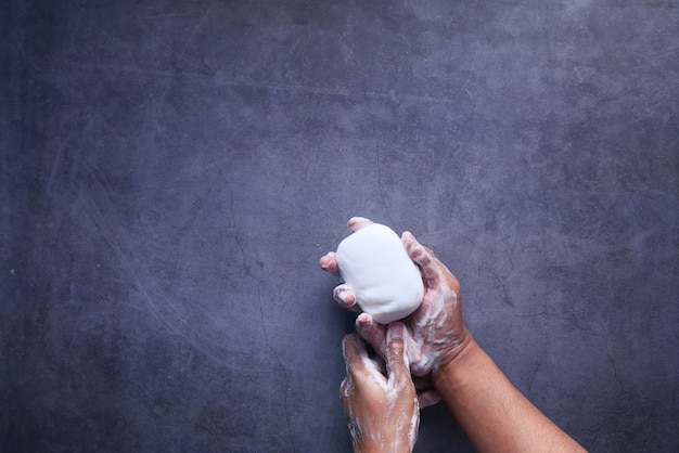 Young man washing hand with soap top view