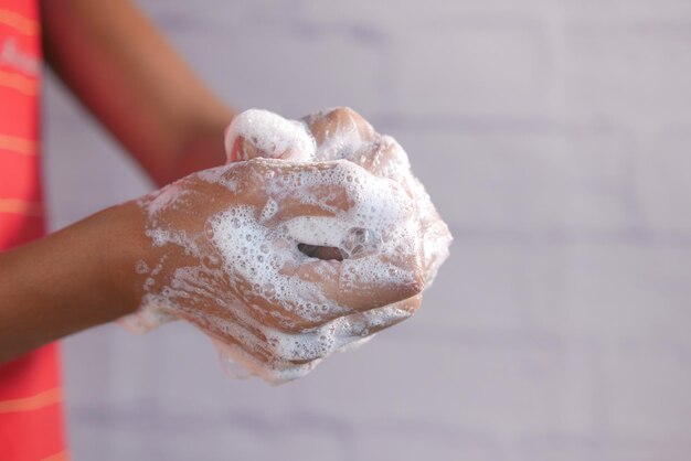 Young man washing hands with soap warm water