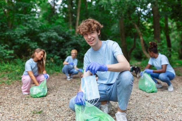 covid19コロナウイルスのパンデミック中にプラスチックごみから医療廃棄物またはPPE廃棄物を分離するのに忙しい若い男性の廃棄物収集業者