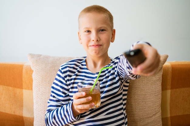 Young man watches tv using remote control to change channels\
guy got bored with what he sees on tv s...