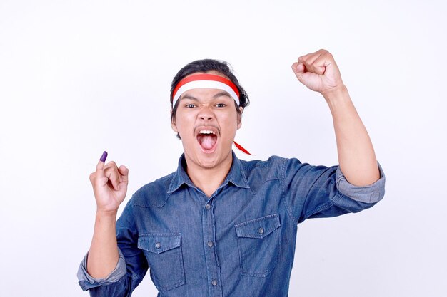 Young man wear headband raising fist and screaming to the camera while showing little finger after