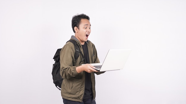 The young man wearing bag shouting and yelling on a white space with laptop