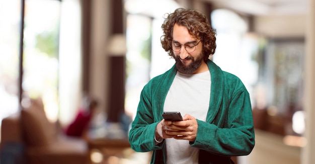 Young man wearing bathrobe night suit with a smart phone