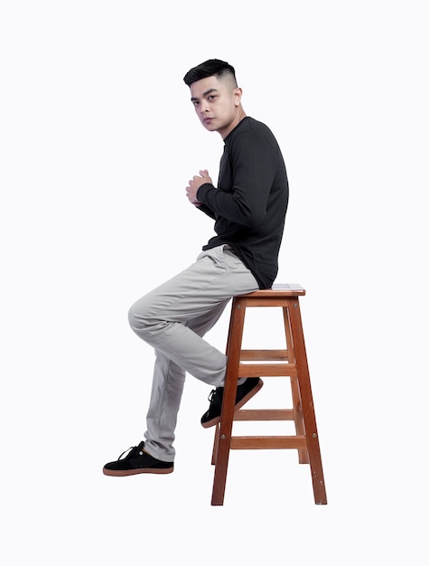 Young man wearing black long sleeve t shirt was sitting in chair