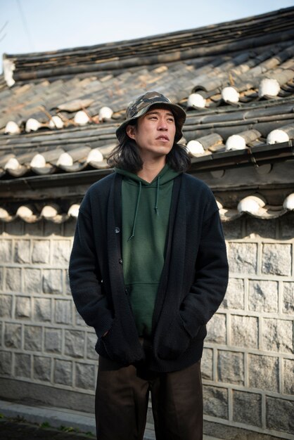 Photo young man wearing a bucket hat in the city