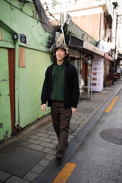 Foto giovane che indossa un cappello da pescatore in città