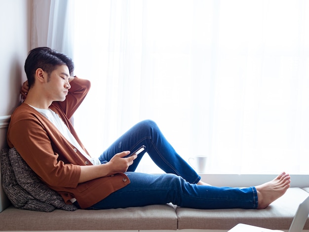 Young man wearing casual clothes and using mobile phone