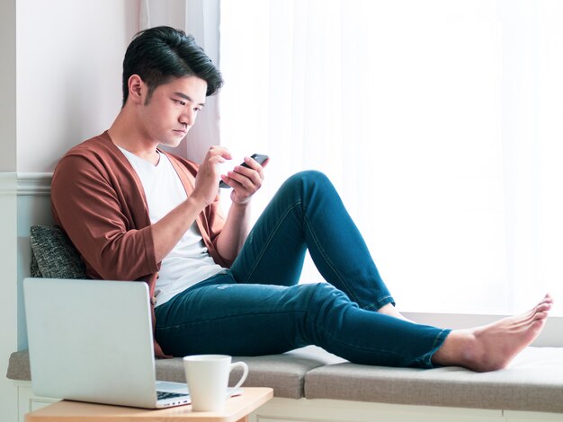 Young man wearing casual clothes and using smartphone