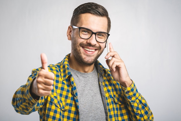 Young man wearing a casual shirt and eyeglasses using the phone