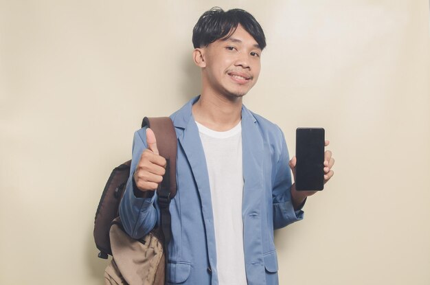 Young man wearing college suit carrying phone and backpack on isolated background