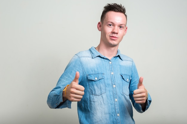 young man wearing denim shirt against white space