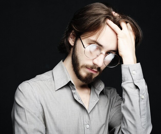 Young man wearing eyeglasses over black background Lifestyle co