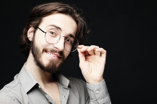 Young man wearing eyeglasses over black background Lifestyle concept