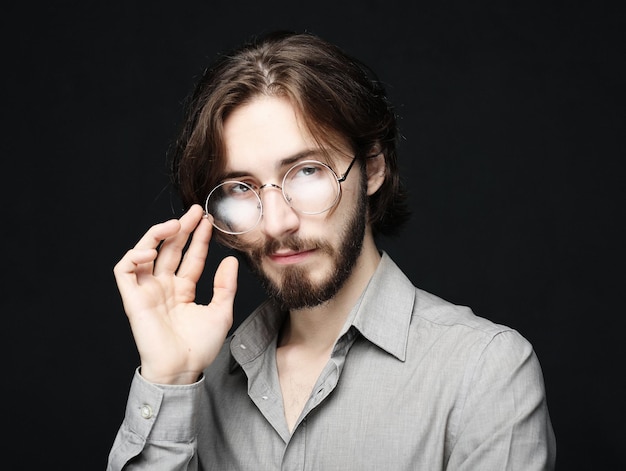 사진 검정 배경 위에 안경을 쓴 젊은 남자