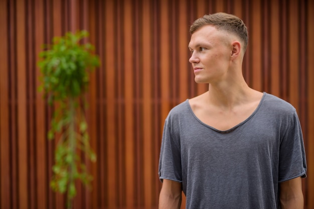 Young man wearing gray shirt in the streets outdoors