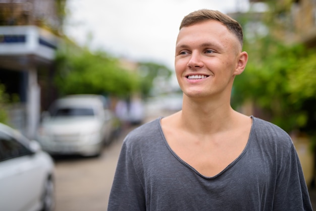 Young man wearing gray shirt in the streets outdoors