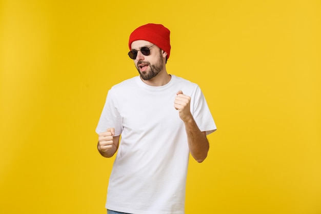Young man wearing hat standing against yellow background