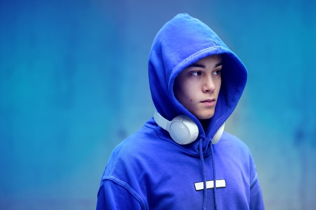 Young man wearing a hoodie with earphones