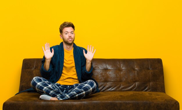 Young man wearing pajamas looking nervous, anxious and concerned, saying not my fault or I didnÃ¢ÂÂÃÂÃÂ´t do it