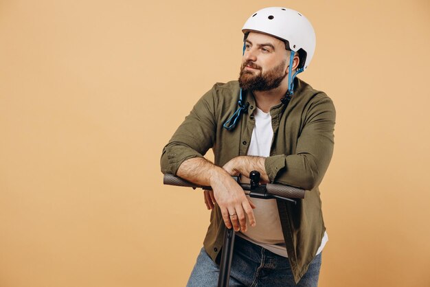 Young man wearing safety helmet and riding electric scooter