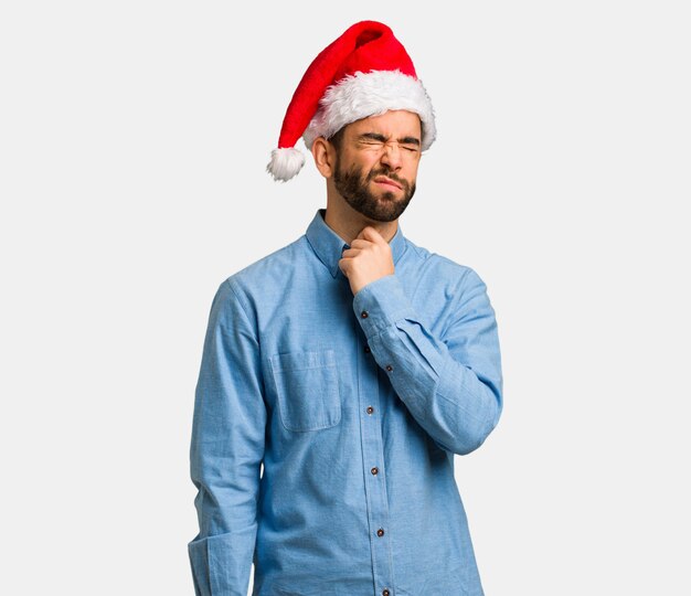 Young man wearing santa hat coughing, sick due a virus or infection