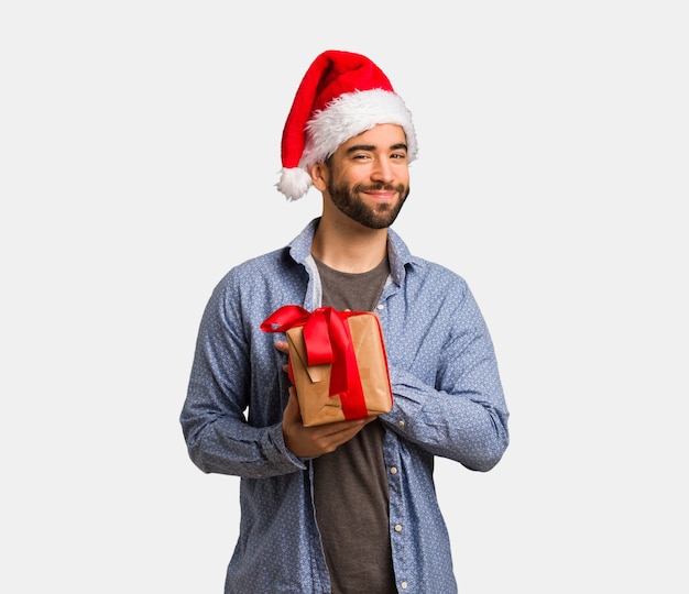 Young man wearing santa hat doing a romantic gesture