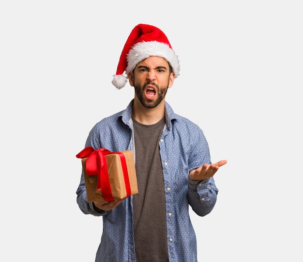 Young man wearing santa hat doing a timeout gesture