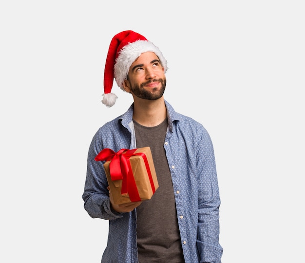 Young man wearing santa hat dreaming of achieving goals and purposes