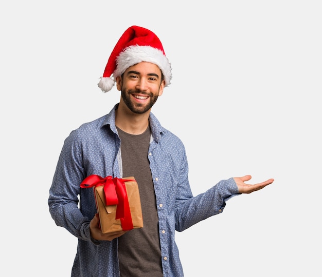 Giovane uomo che indossa cappello santa tenendo qualcosa con le mani