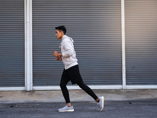 Young man wearing sportwear, jogging on road,for\
exercise,blurry light around